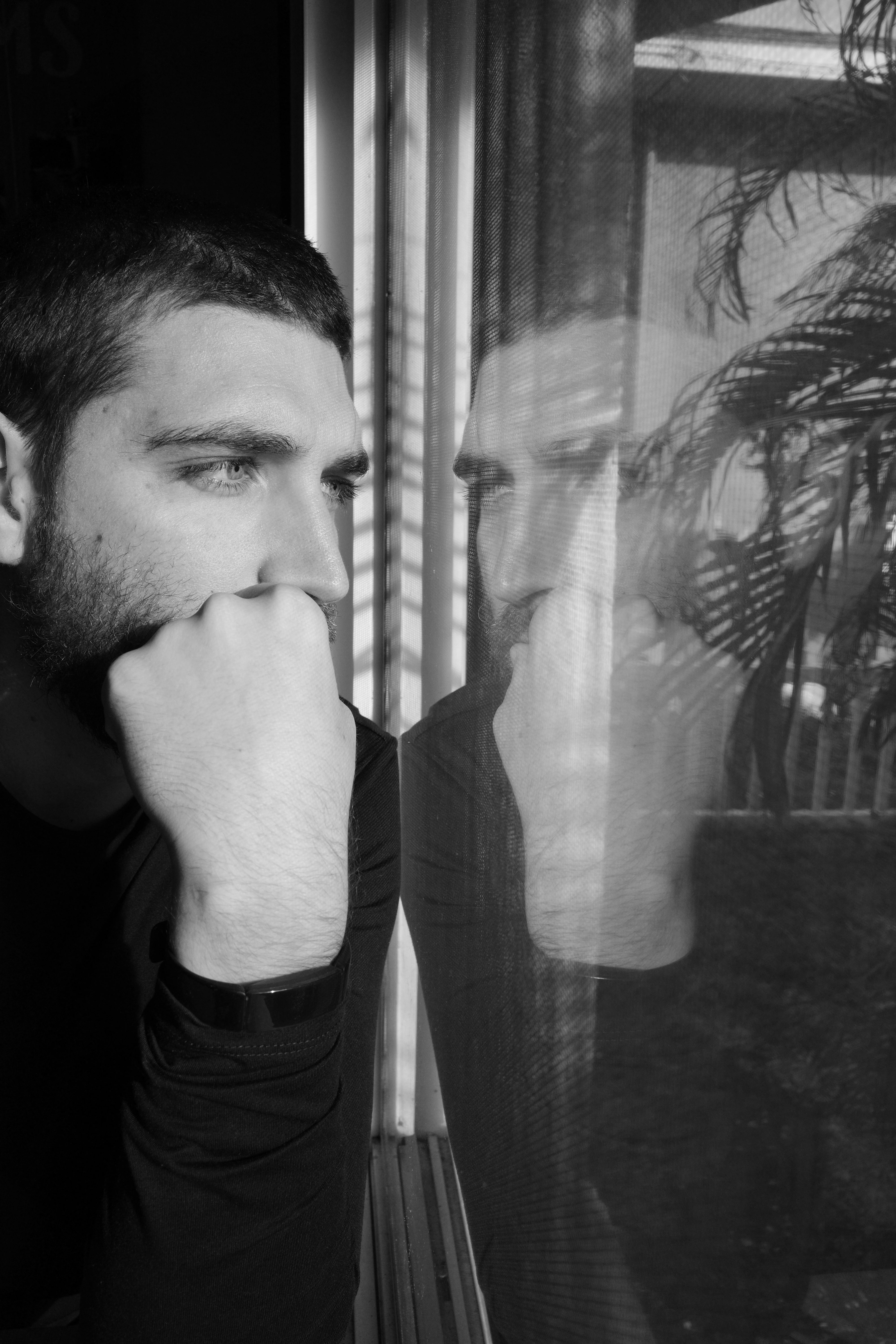 A monochromatic self-portrait - me looking out the window while my reflection on the window looks back at me.