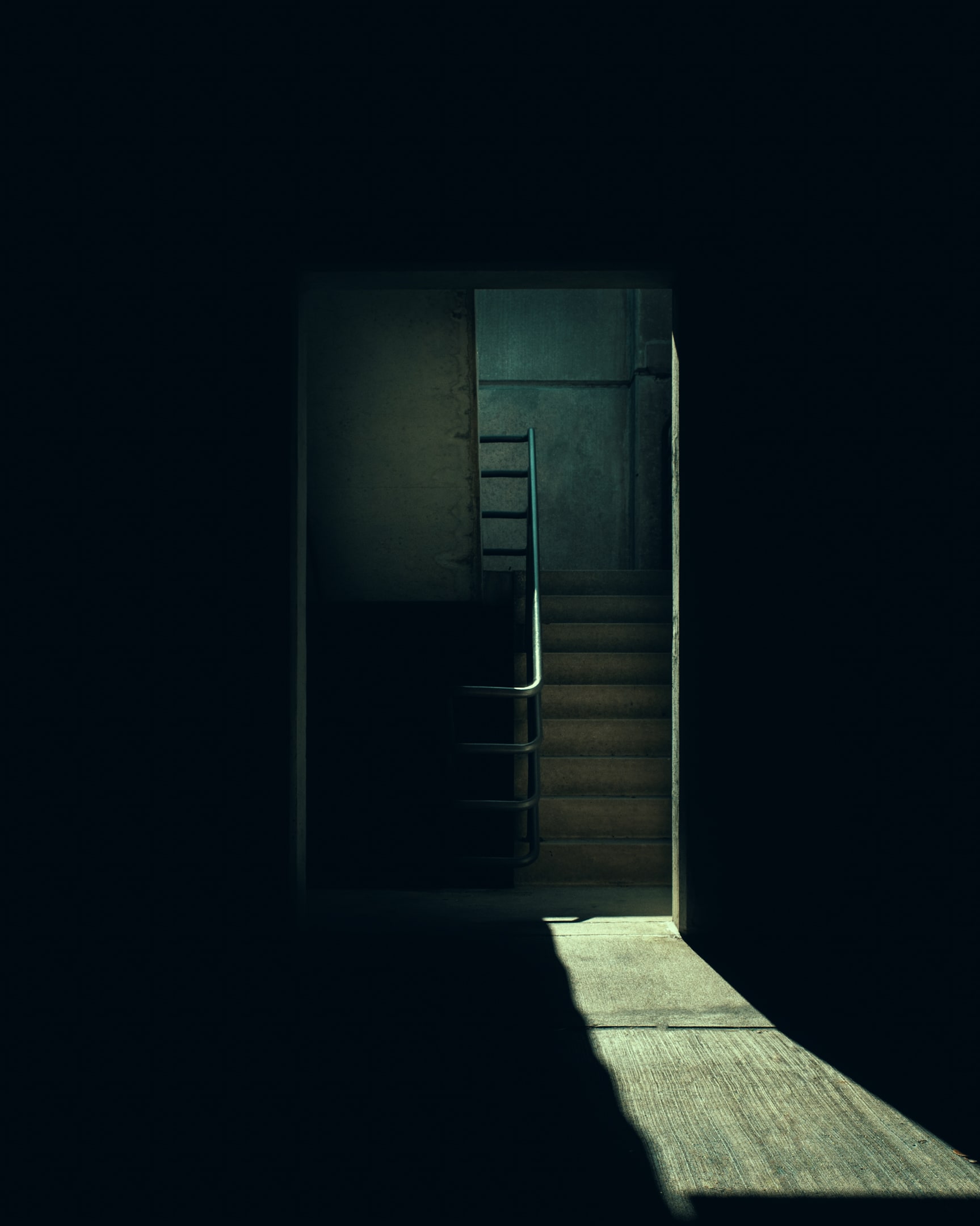 A dark and cool stairway leading down to darkness and up to light